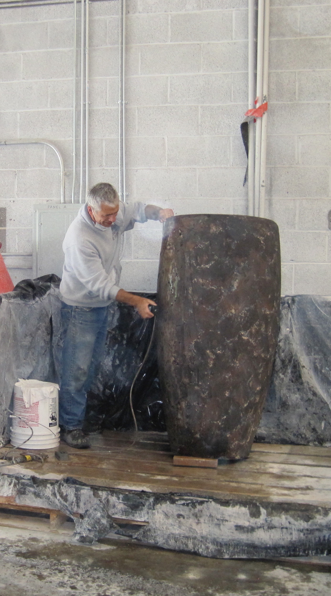 Buddy hand-finishing a concrete vessel