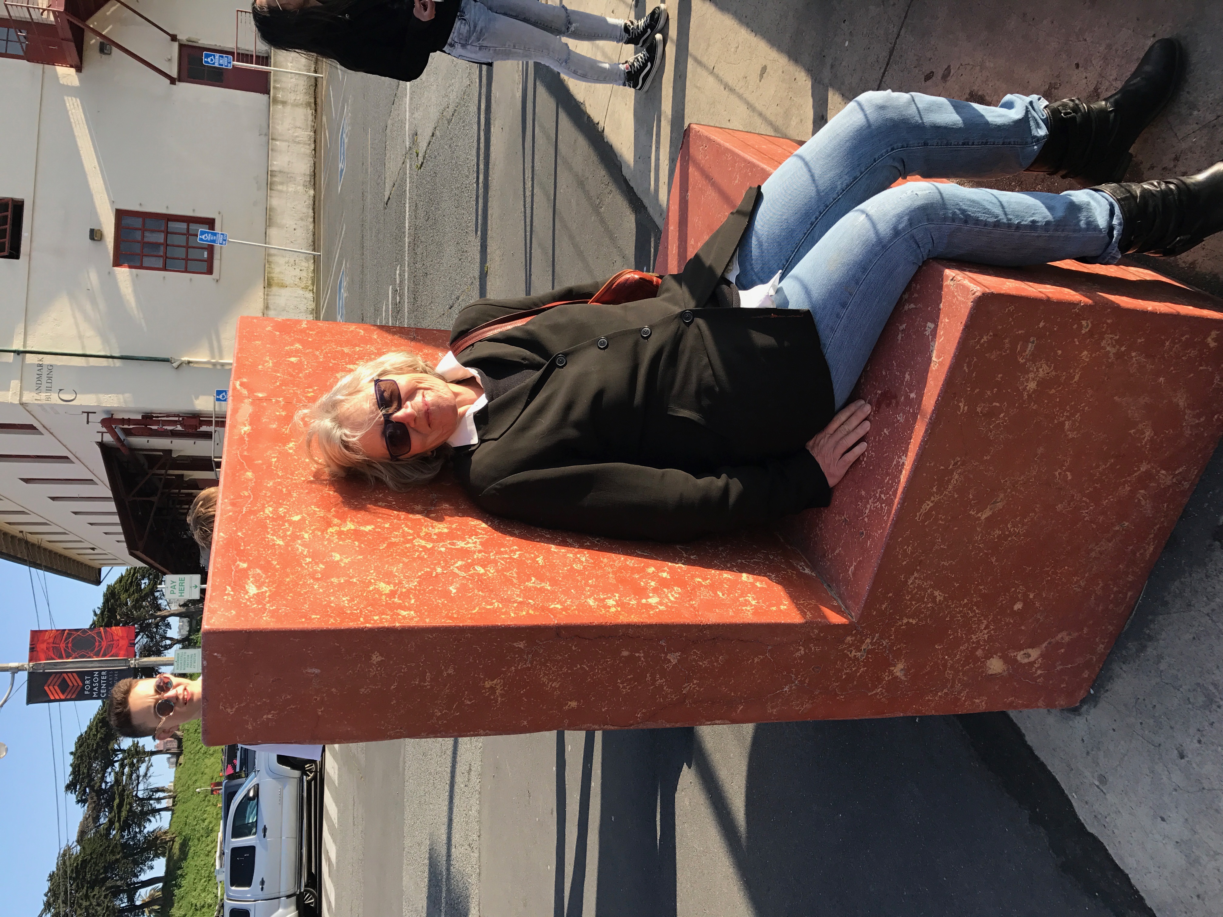 Buddy sitting on a red concrete bench