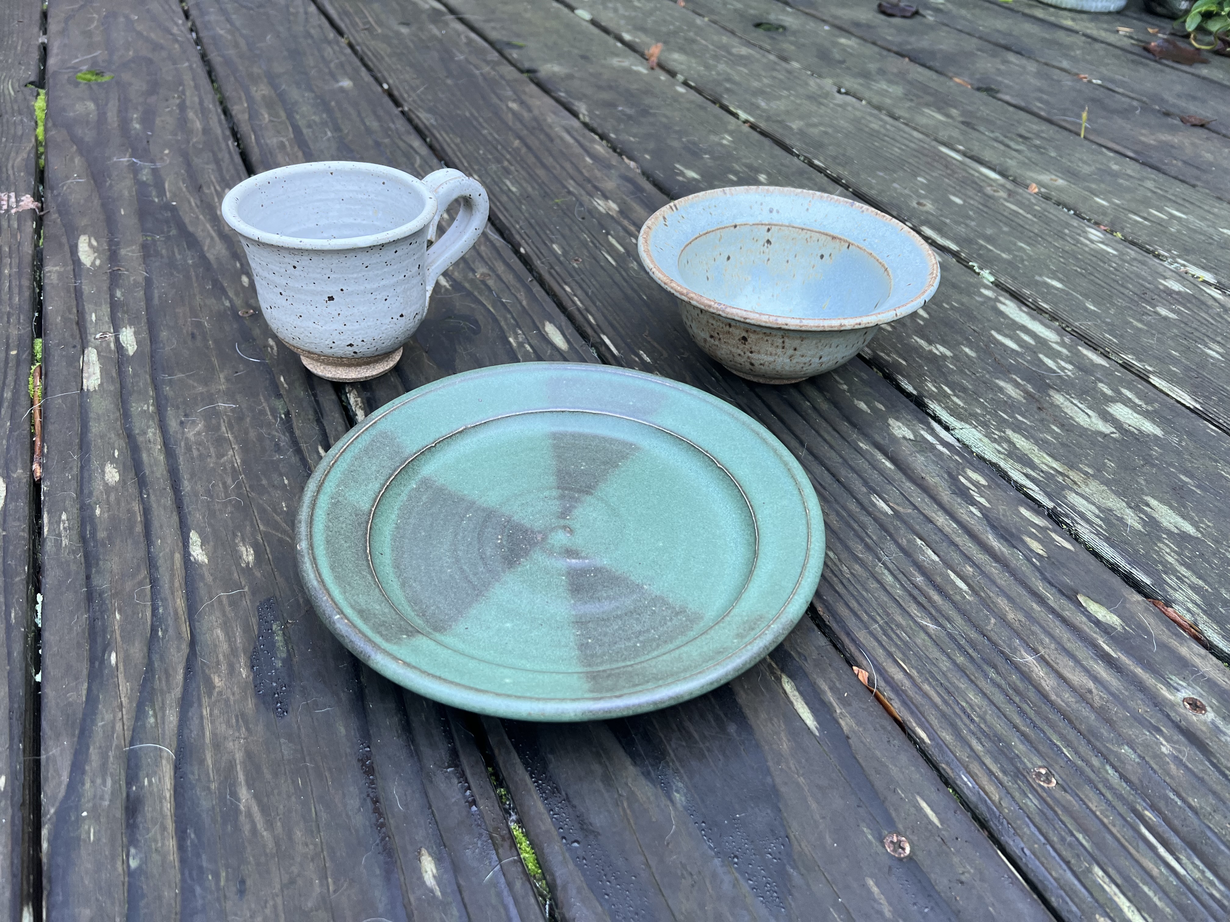 Speckled plate with spiral center and white bottle vase
