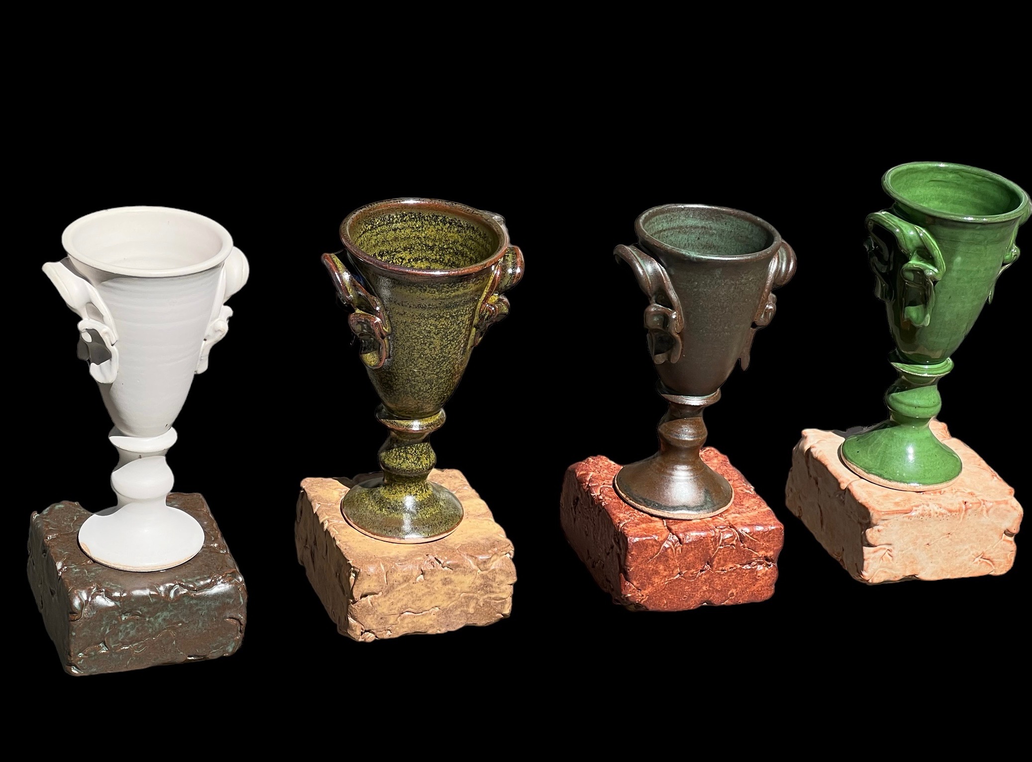 Four chalice vases on stone bases in white, olive, bronze, and green